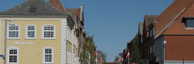 Gadeforløb i Bjerringbro med flag og ældre byhuse